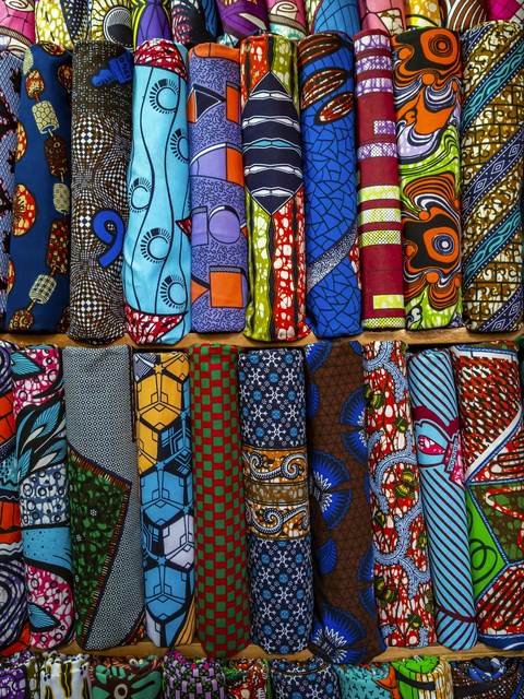 Rolls of colourful African wax-print fabric.
